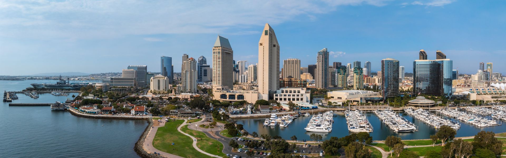Aerial view of San Diego's skyline featuring high rise buildings, the Marriott Marquis, Manchester Grand Hyatt, a marina, and San Diego Bay.